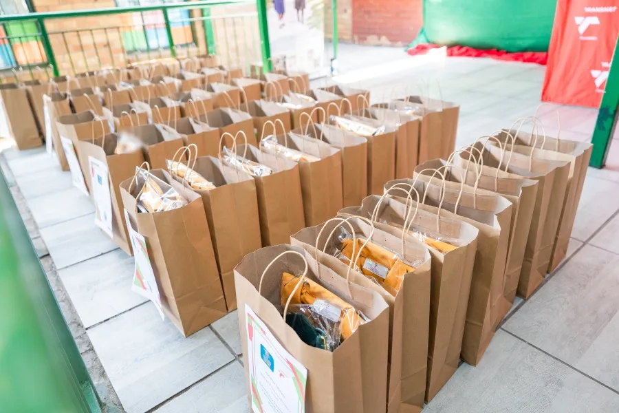 Rows of individually labelled uniform bags laid out before the Inxiweni Primary School handover