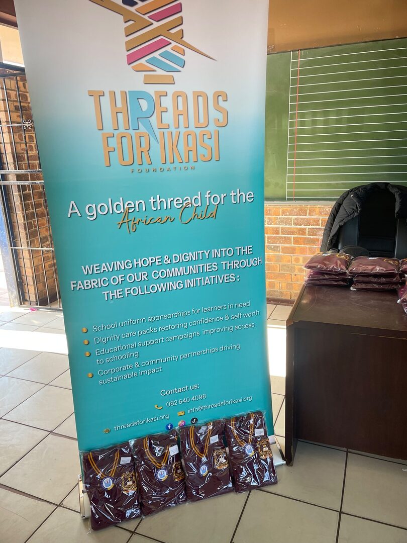 The Threads for iKasi Foundation banner with labelled Thuthuka Primary School jerseys stacked at its base