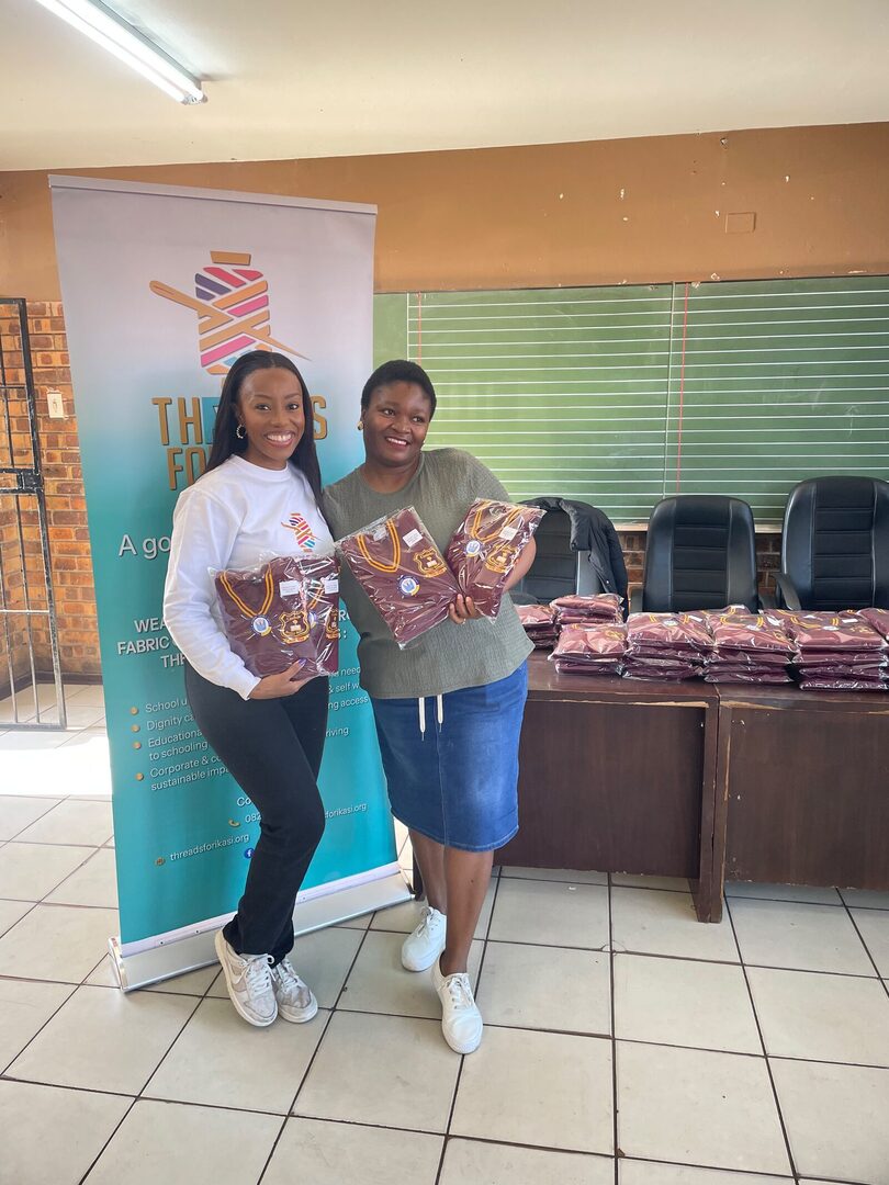 Threads for iKasi Foundation representatives holding labelled Thuthuka Primary School jerseys ready for handover