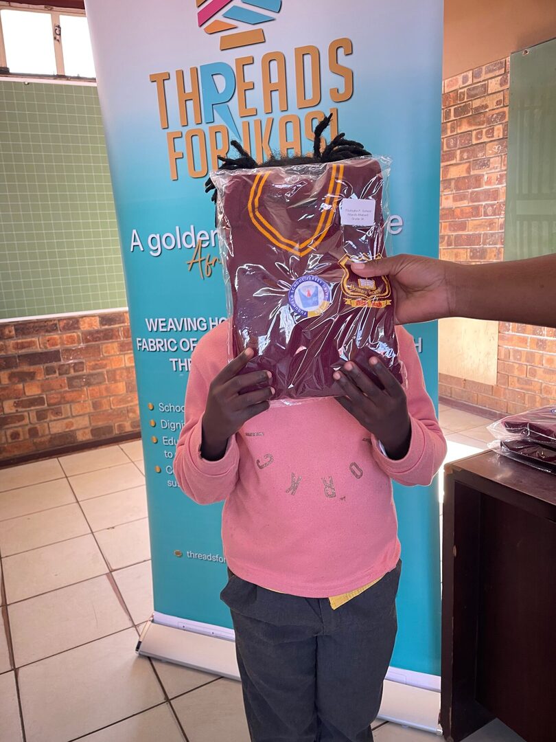 A Thuthuka Primary School learner holding a sealed ZS Uniforms jersey labelled with their own name, school and grade, 30 July 2026