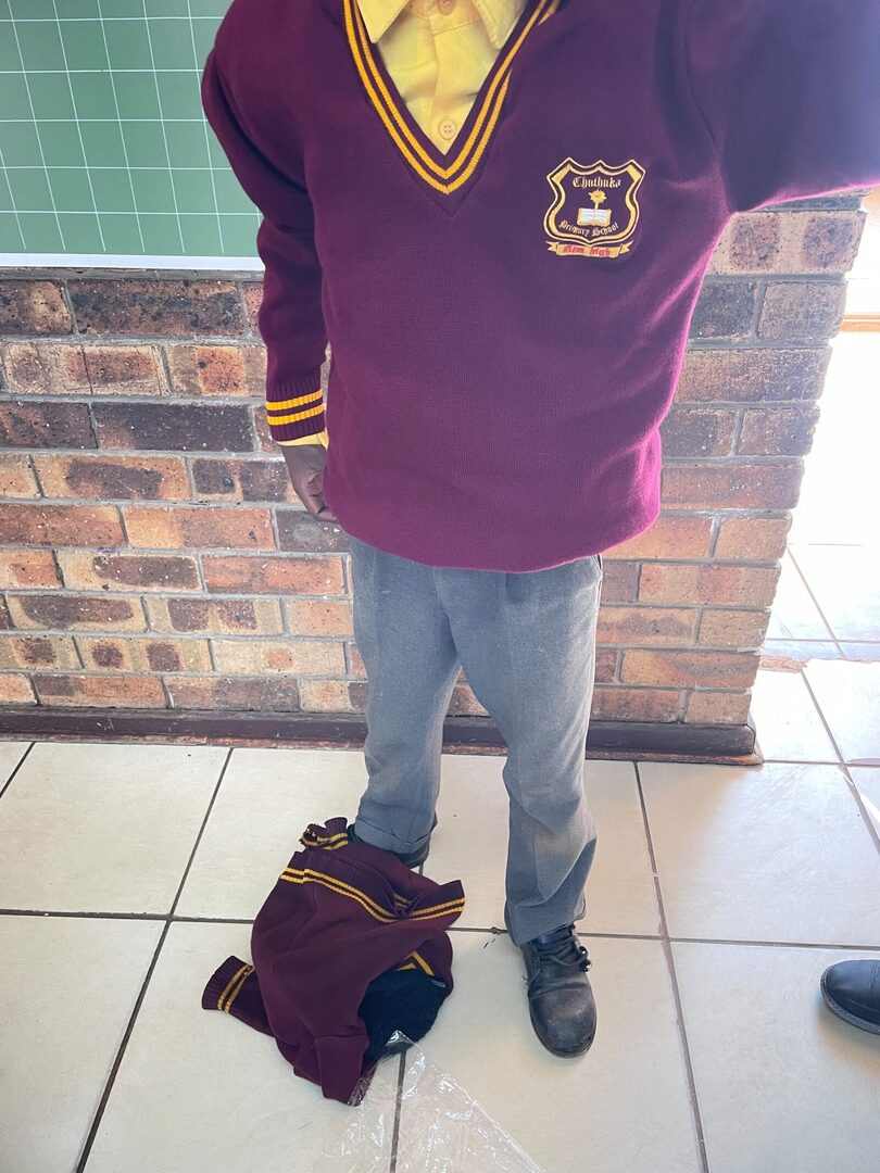 A Thuthuka Primary School learner wearing a new maroon and gold ZS Uniforms school jersey